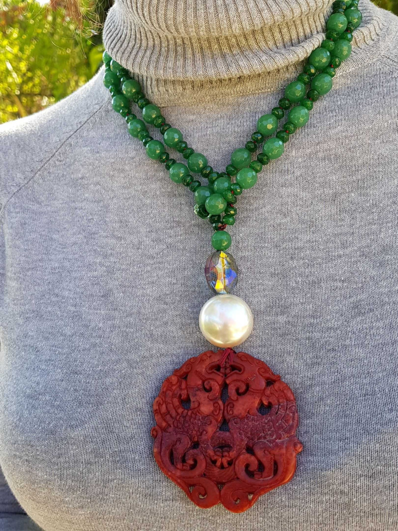 Long necklace with green agate, mother-of-pearl bead, and red jade medallion.