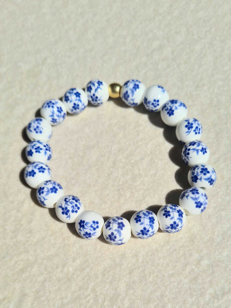 Elastic bracelet with ceramic beads and a floral design.