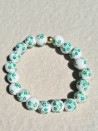 Elastic bracelet with ceramic beads and a floral design.