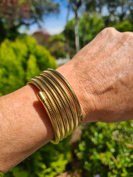 Pulsera de acero bañada en oro con diseño de tubo en espiral. Estilo moderno