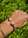 Pulsera de acero abierta con perlas elegantes dorada o plateada
