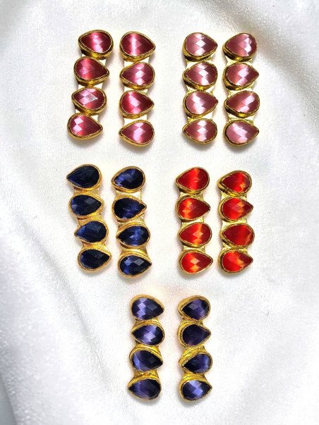 Pendientes dorados largos y artesanales con cuatro piezas en forma de lágrima facetada.